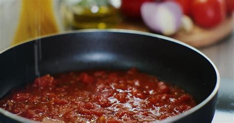 Een pan met sudderende tomatensaus, waarin de ingrediënten langzaam samenkomen.