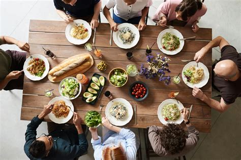 Foto van een gezellige brunch met diverse mensen aan tafel, gesprekskaarten op tafel