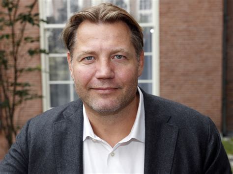 Dennis van der Geest met een groep lachende 80-jarigen op een exotische locatie.