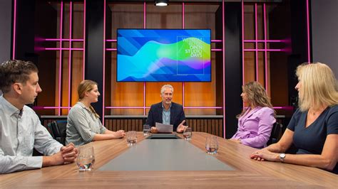 Illustratie van een talkshowtafel met presentator en gasten die discussiëren.