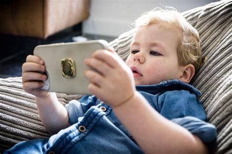 Illustratie van een kind dat opgewonden naar een tablet kijkt met diverse cartoonfiguren op het scherm.