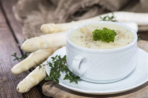 bord met verse aspergesoep, gegarneerd met peterselie en stukjes asperge