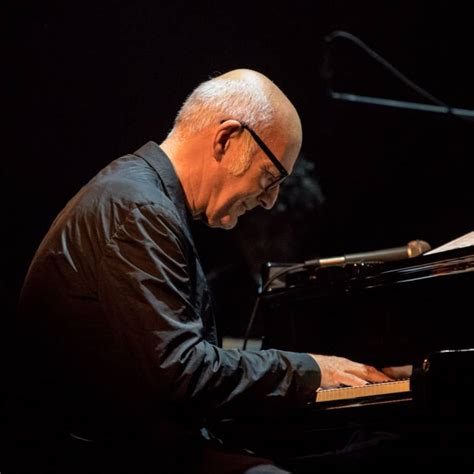 Een sfeervolle foto van Ludovico Einaudi tijdens een concert of opname.