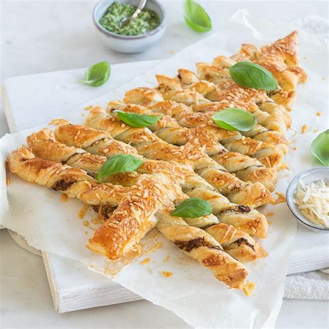 Een feestelijk gedekte borrelplank met bladerdeeg sterren en een bladerdeeg kerstboom