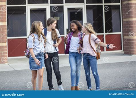 Een groep tieners die samen lachen op de middelbare school.
