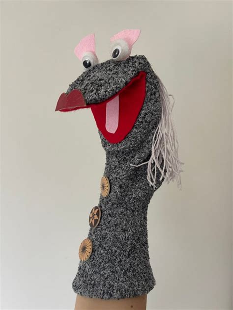 Een kleurrijke sokpop met grote pompons als hoofdversiering en zelfgemaakte vilten oren.