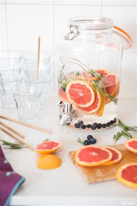Foto van een karaf met grapefruitwater, rozemarijn en ijsblokjes