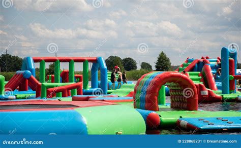 Een artistieke impressie van een kleurrijke, waterrijke hindernisbaan met deelnemers.