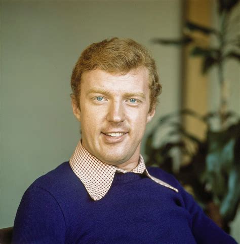 Foto van een jonge André van Duin met een microfoon