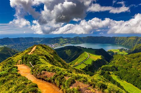 Panoramisch uitzicht over de groene, vulkanische landschappen van de Azoren, met de blauwe oceaan op de achtergrond.