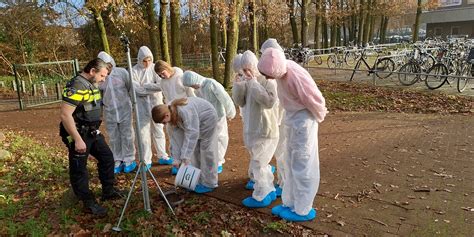 Vrouw in uniform onderzoekt een plaats delict bij een bouwkraan in Amsterdam-Noord.