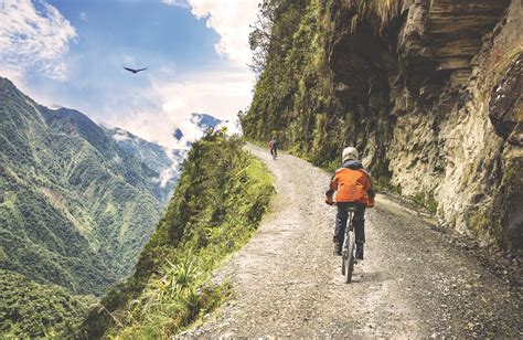 Mountainbikers op de Death Road in Bolivia, met een steile afgrond naast de smalle weg.