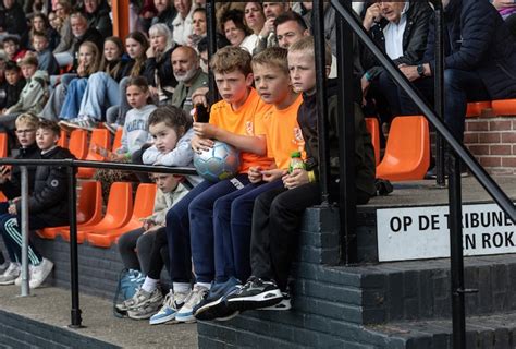 Een groep mensen kijkt gespannen toe vanaf de tribune van Renbaan Duindigt.