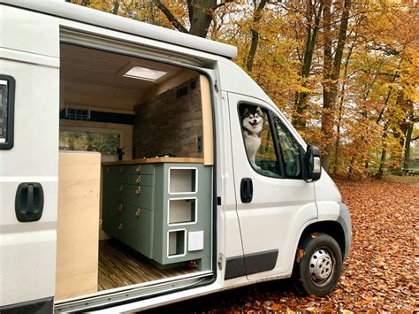 Illustratie van een omgebouwde camperbus met openstaande deuren, waaruit een persoon kijkt.