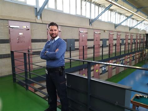 Illustratie van een gevangenisbewaarder die kalm een potentieel gevaarlijke situatie de-escaleert.