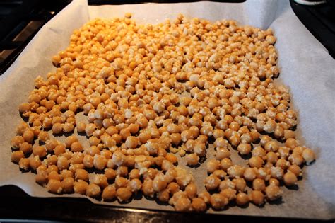 kikkererwten verspreid op een bakplaat in de oven