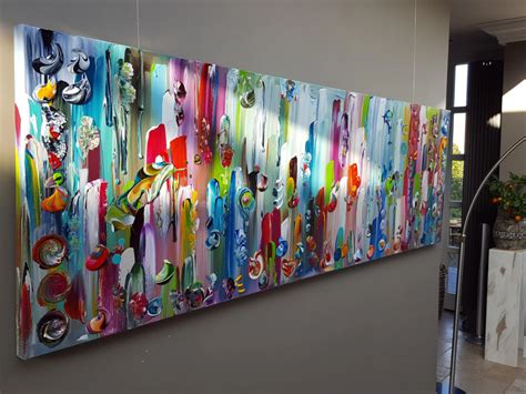 Voorbeeld van een tentoonstellingsruimte met gelaagde en kleurrijke kunstwerken