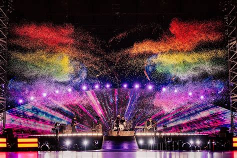 Een podium met een tribute band die de sfeer van Coldplay nabootst, inclusief lichteffecten.