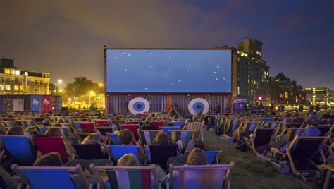 Illustratie van een openlucht bioscoop met een projectiescherm en publiek dat op dekens zit