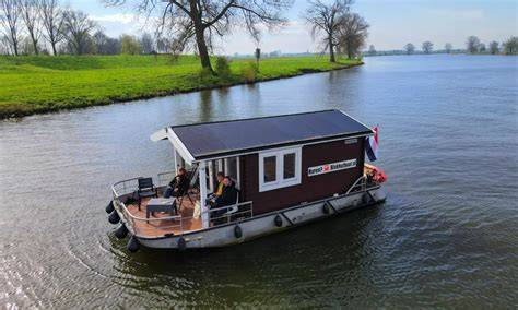 Illustratie van de hybride aandrijving van de blokhutboot met zonnepanelen.